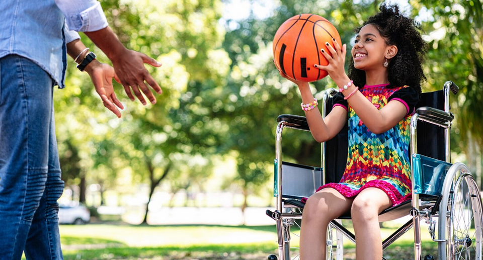 photo jeune fille dans un fauteuil roulant avec un ballon